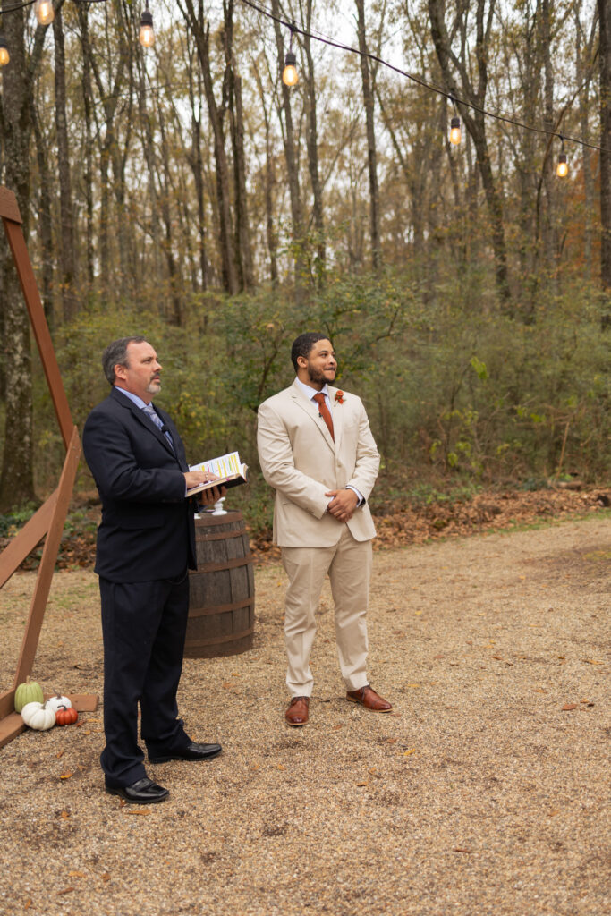 Groom waiting for the bride at the altar after the first look next to the officiant