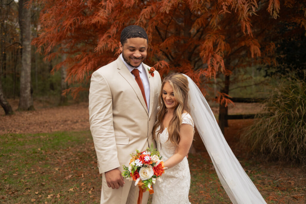 Bride and groom couple's portraits in front of orange Autumnal tree at 2425 warehouse in Monroe, GA